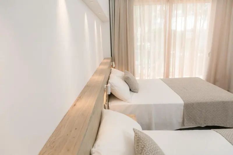 Une chambre avec deux lits simples et une décoration sobre.