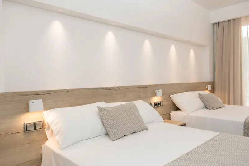 Une chambre lumineuse avec deux lits simples et une décoration sobre.