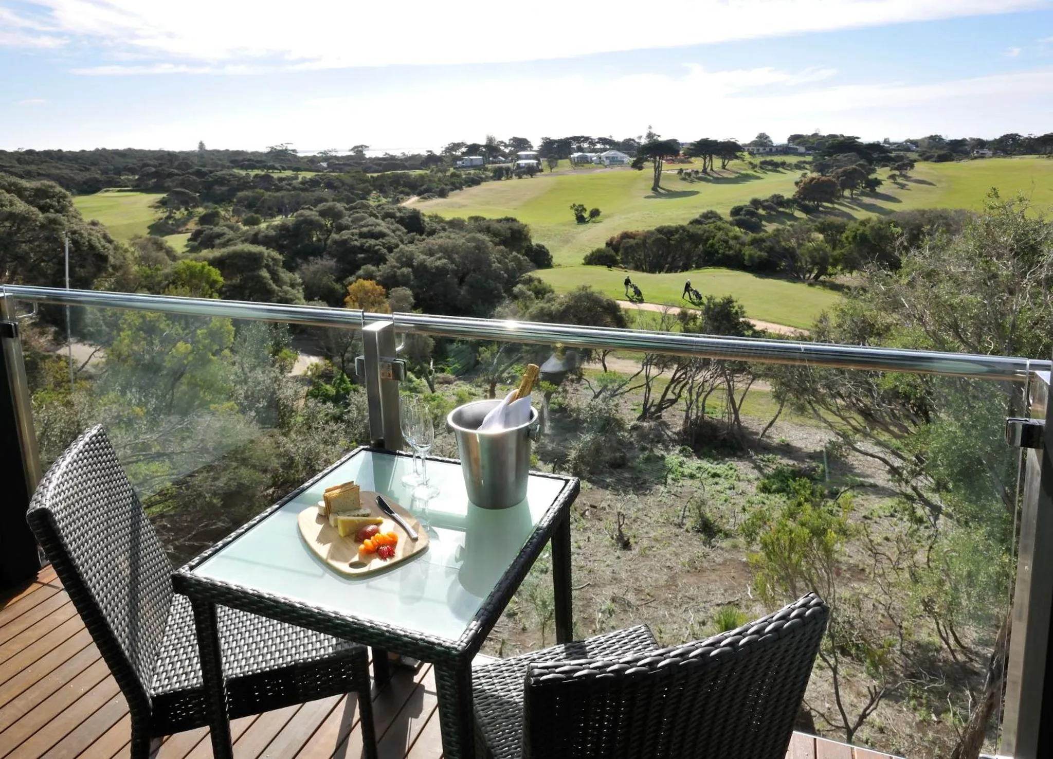 Une table avec des boissons et des en-cas sur une terrasse avec vue sur un paysage verdoyant.