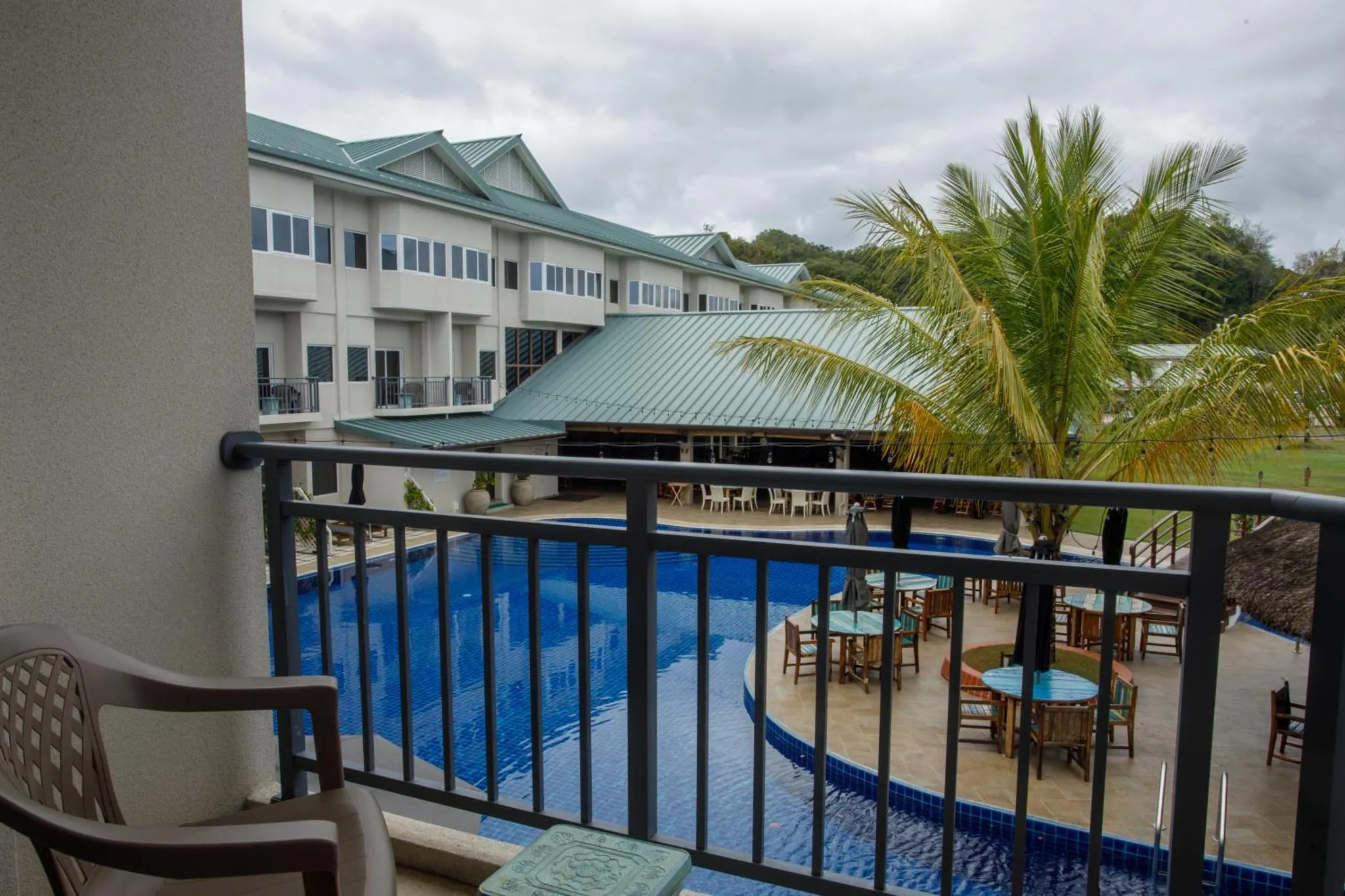 Vue d'une piscine et d'une terrasse depuis un balcon.