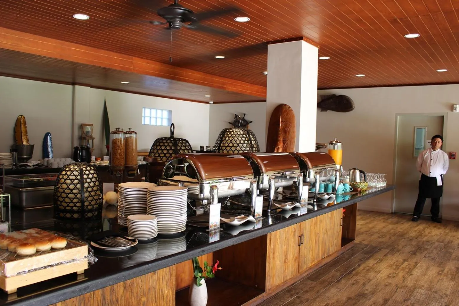 Un buffet propose une variété de plats et de boissons dans une salle lumineuse.