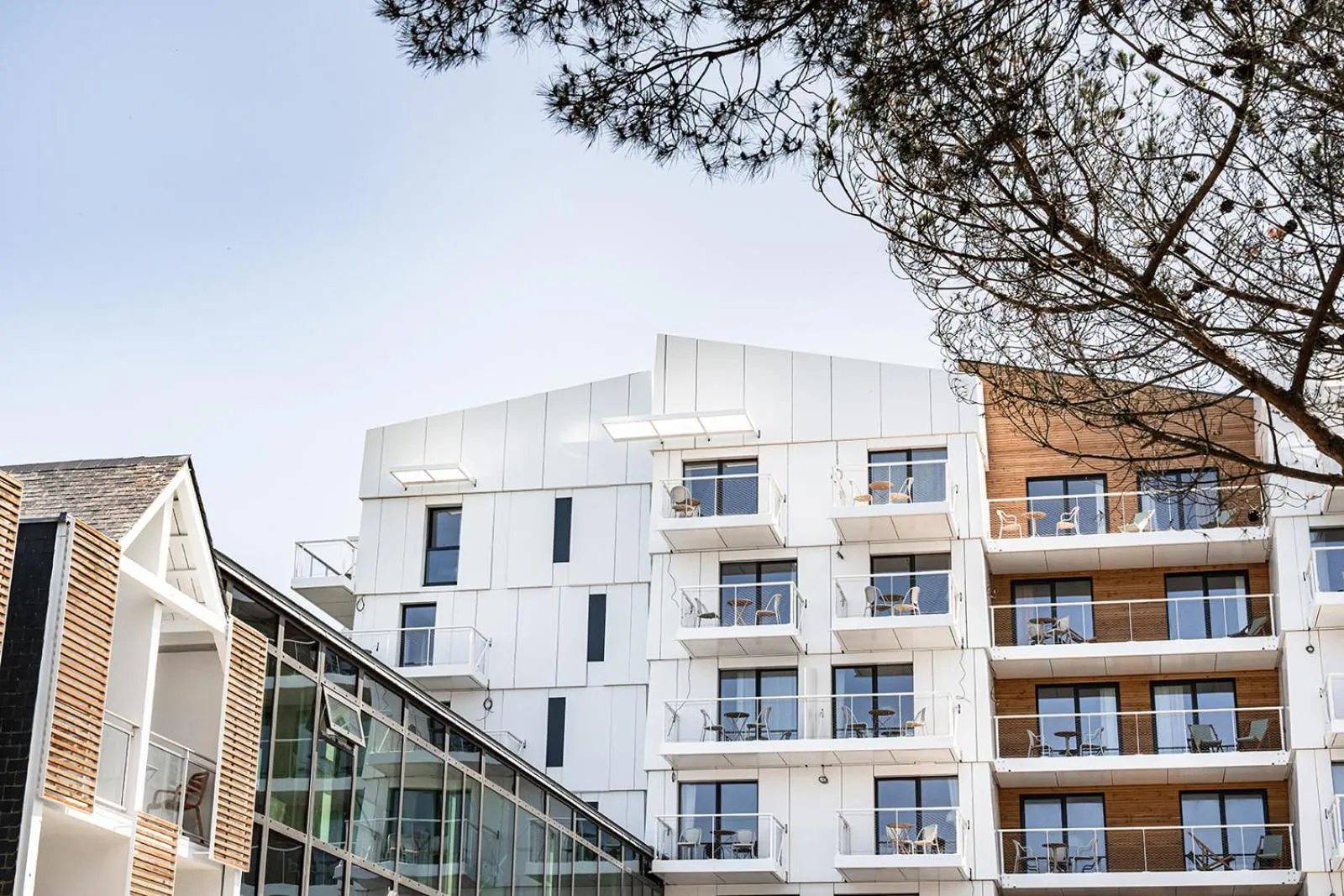 Bâtiment moderne à balcons avec vue sur la mer.