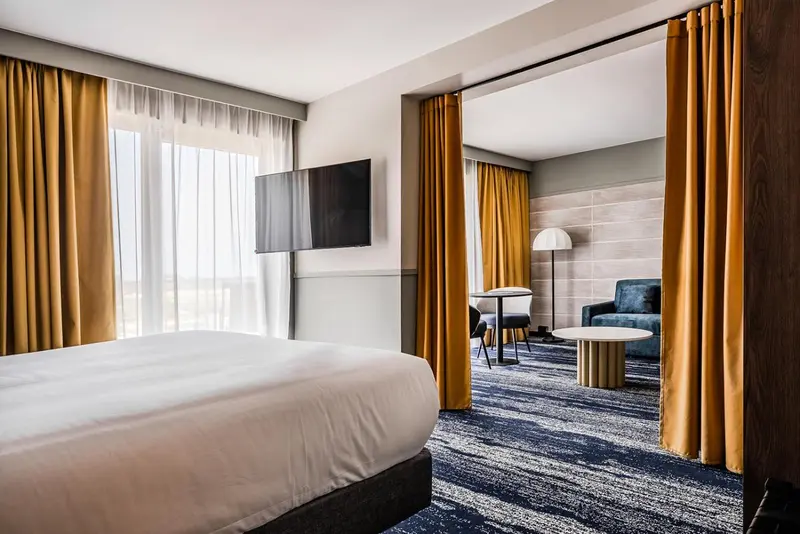 Une chambre lumineuse avec un lit et un espace salon.