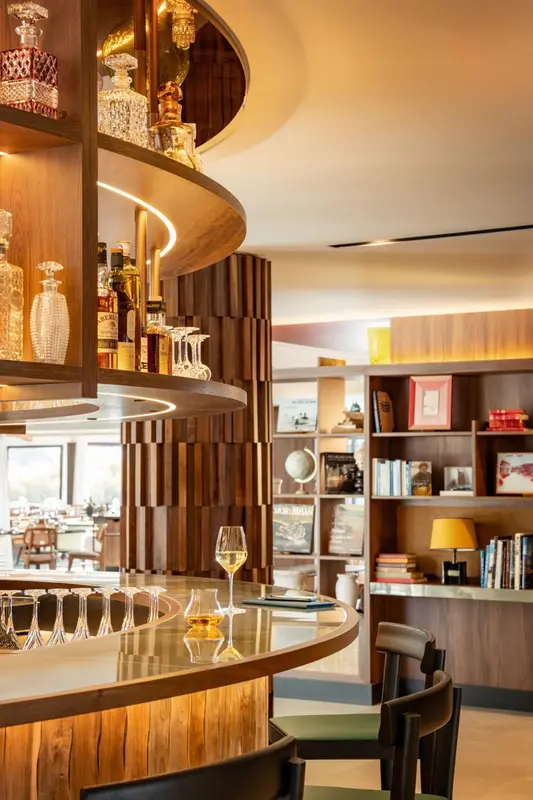 Un comptoir de bar en bois avec des bouteilles et des verres.