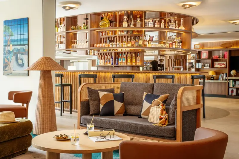 Un bar moderne avec un comptoir en bois et des canapés confortables.