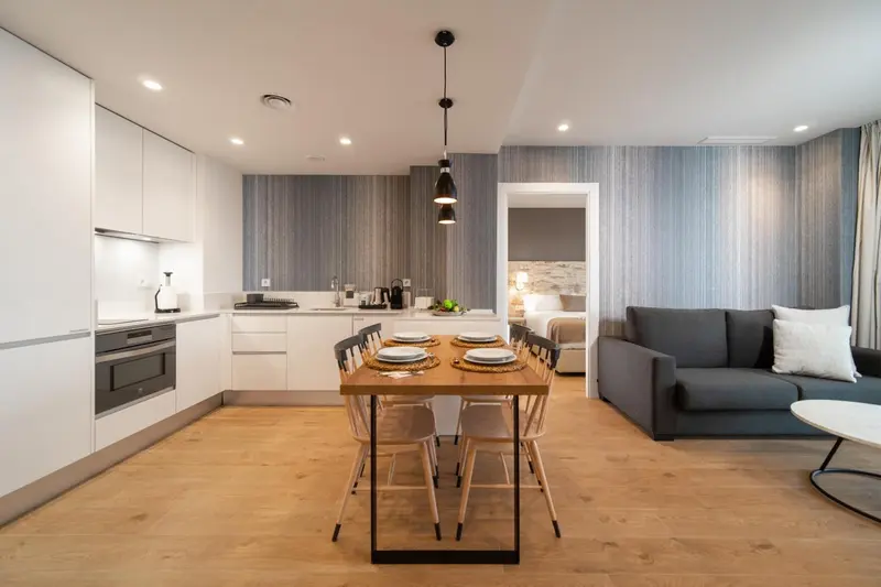 Espace de vie lumineux avec cuisine équipée et table à manger.