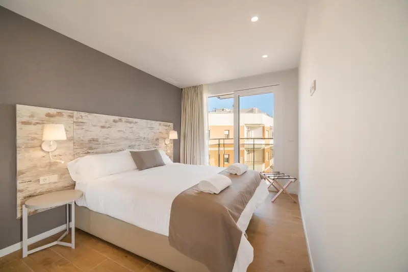 Une chambre lumineuse avec un grand lit et une décoration sobre.