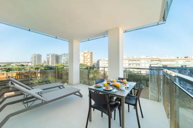 Une table et des chaises sont disposées sur une terrasse avec vue sur la ville.