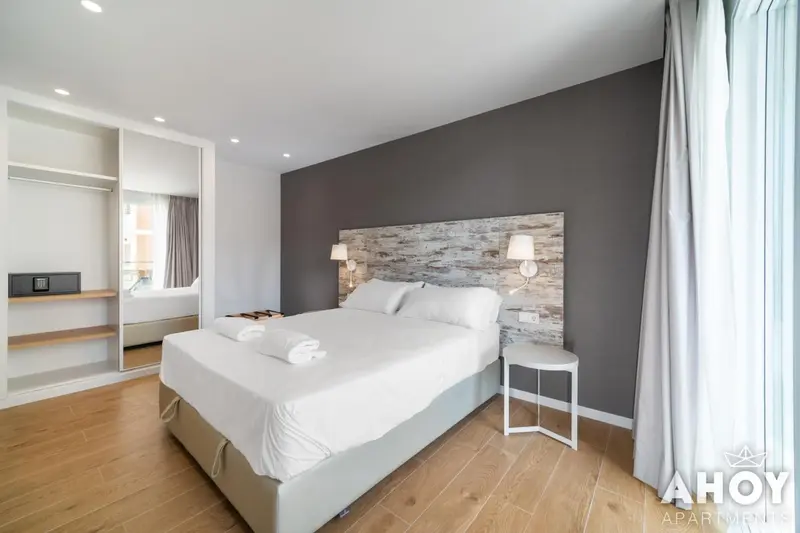 Une chambre lumineuse avec un grand lit recouvert de linge blanc.