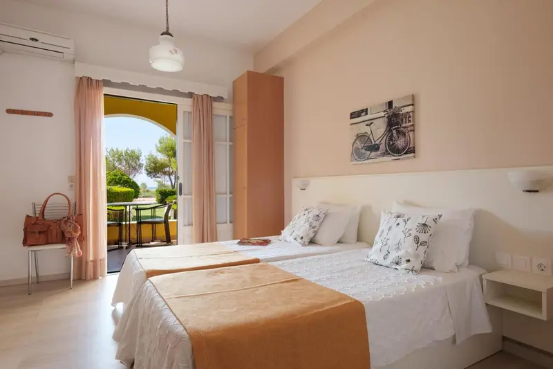 Une chambre lumineuse avec un lit double et un accès à une terrasse.