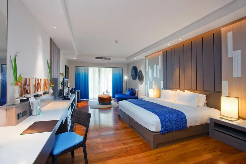 Une chambre spacieuse avec un grand lit et un bureau.