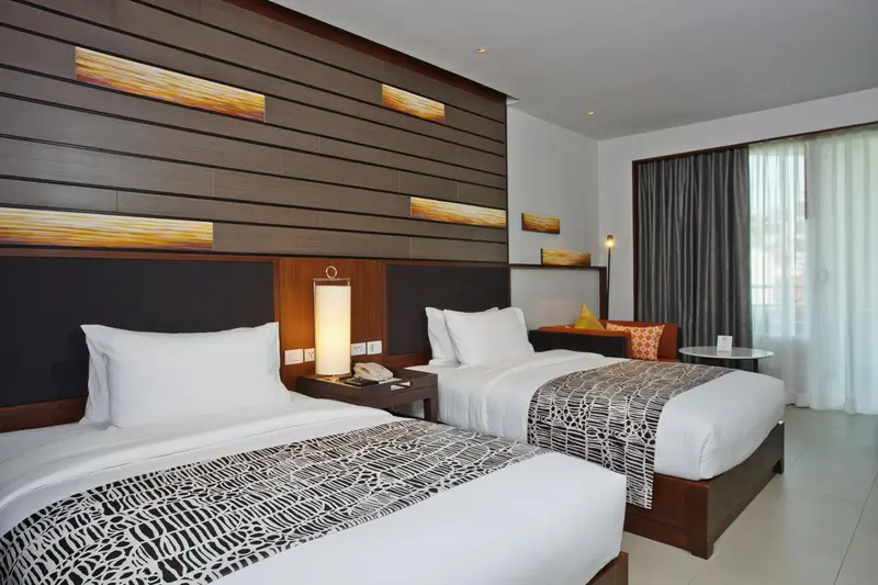 Une chambre d'hôtel moderne avec deux lits simples et une décoration sobre.