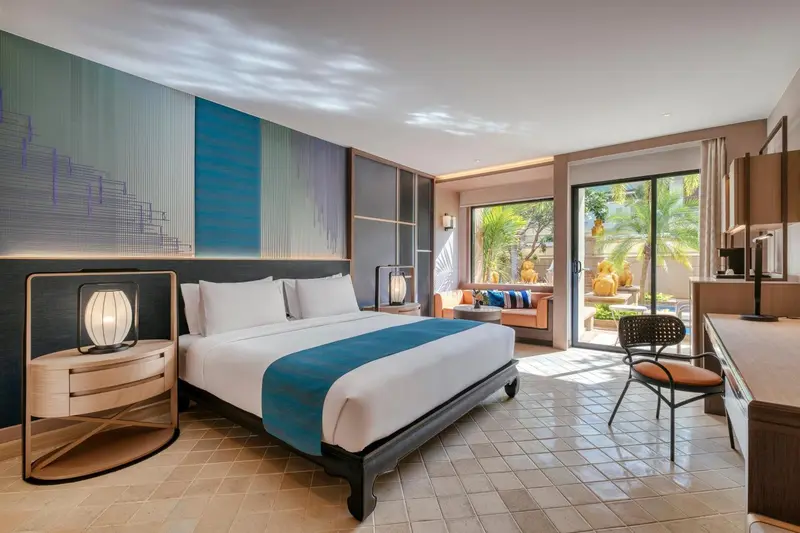 Une chambre lumineuse avec un grand lit et un accès à une terrasse.