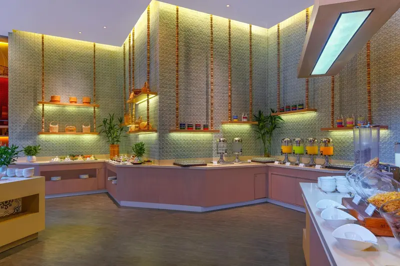 Un buffet propose une variété de plats et de boissons dans un espace lumineux et moderne.