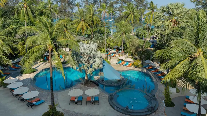 Vue aérienne sur des piscines au milieu d'une végétation tropicale luxuriante.