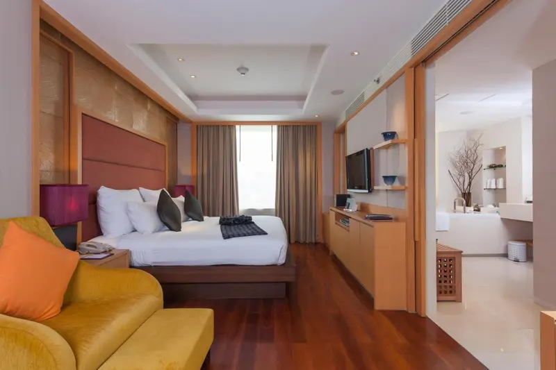 Une chambre lumineuse avec un grand lit et un coin salon.