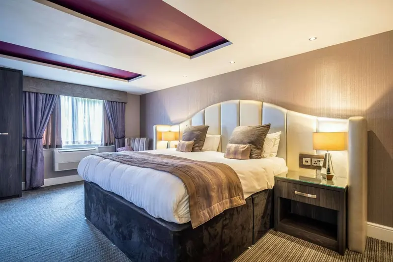 Une chambre spacieuse avec un grand lit et une décoration sobre.