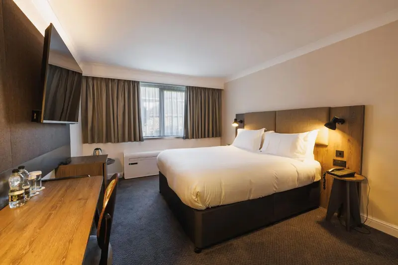 Une chambre d'hôtel avec un grand lit et un bureau.