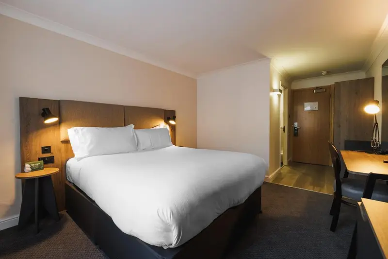 Une chambre d'hôtel moderne avec un grand lit et un bureau.