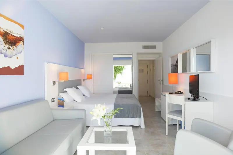 Une chambre lumineuse avec un canapé et un lit double.