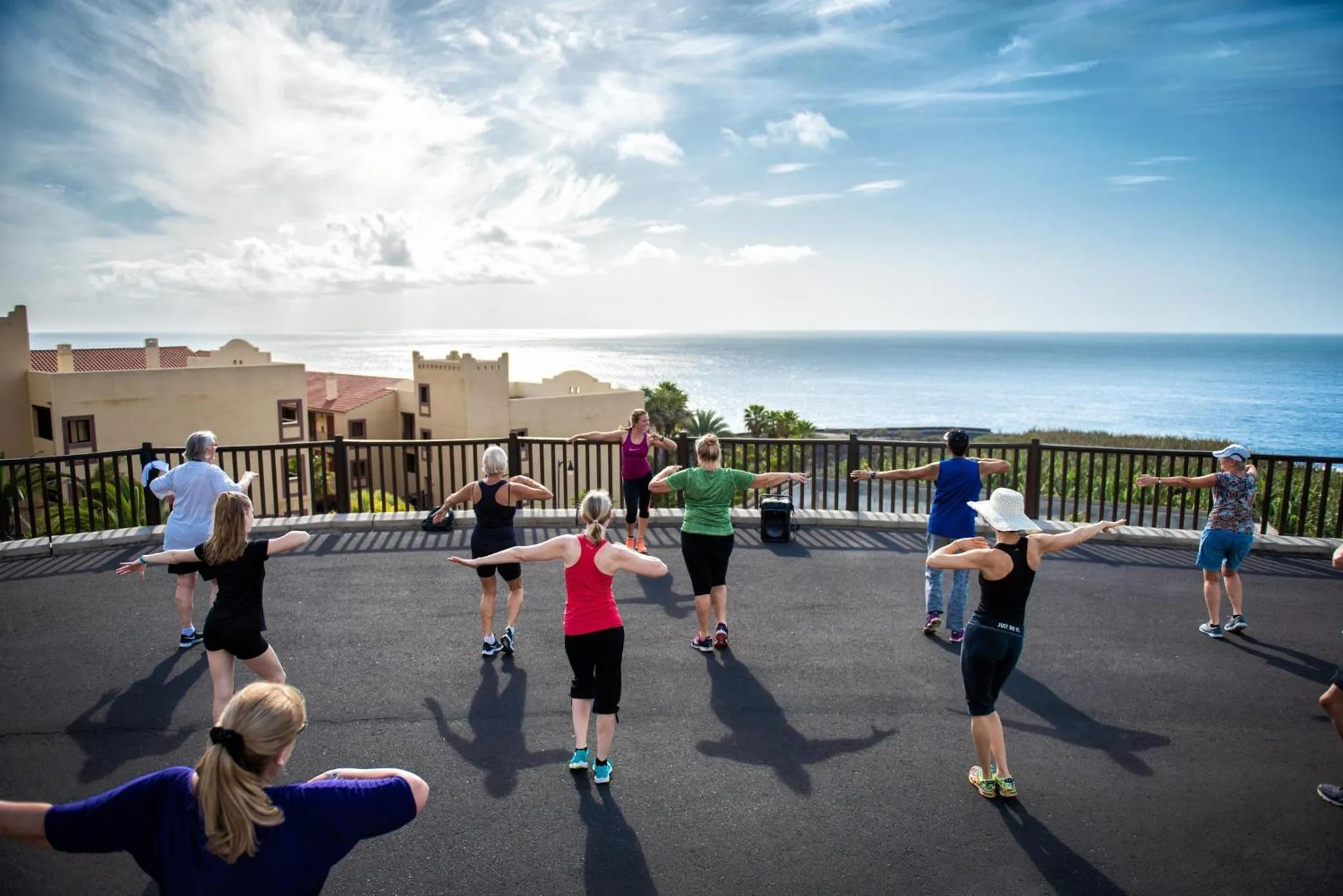 Groupe de personnes pratiquant une activité physique en extérieur avec vue sur la mer.