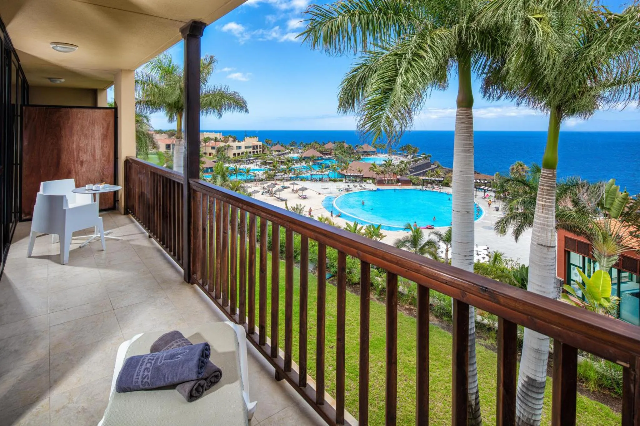 Une terrasse avec mobilier d'extérieur offre une vue sur la mer et une piscine.