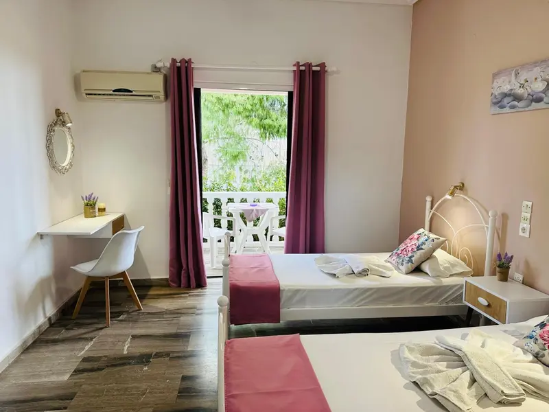 Une chambre lumineuse avec un lit et un bureau près d'une fenêtre.