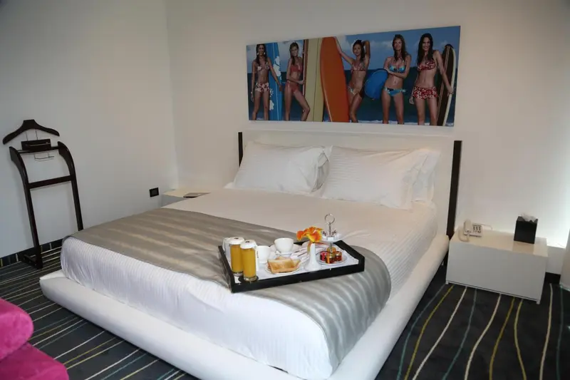 Une chambre d'hôtel avec un grand lit et un plateau petit-déjeuner.