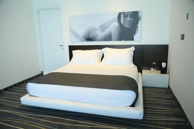 Une chambre moderne avec un grand lit et une décoration murale.