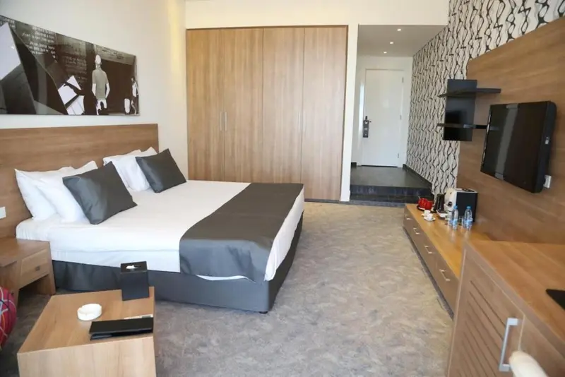 Une chambre moderne avec un grand lit et une télévision murale.