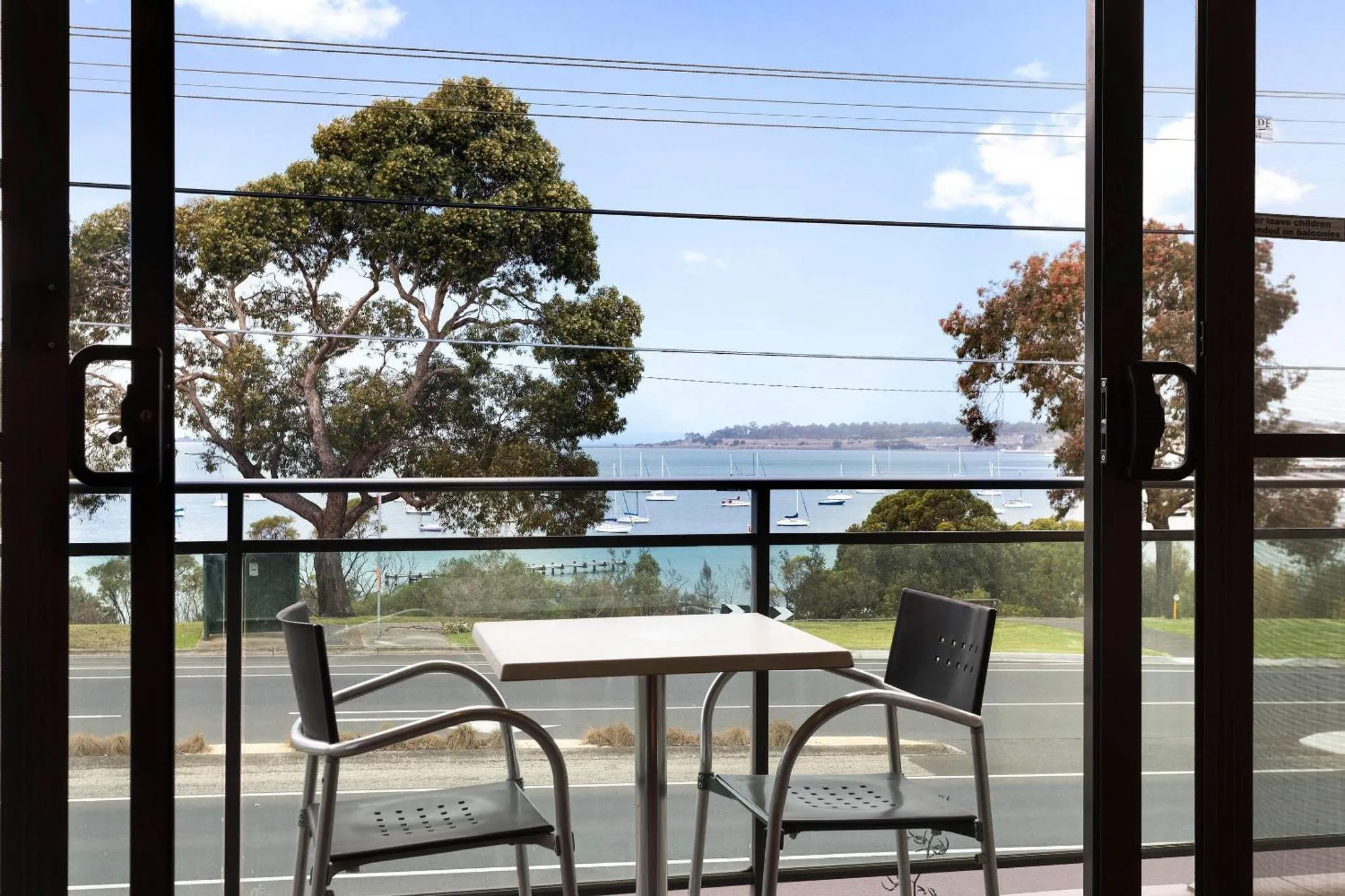 Vue sur la mer depuis une terrasse avec mobilier de jardin.