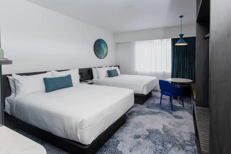 Une chambre d'hôtel moderne avec deux lits et un coin salon.