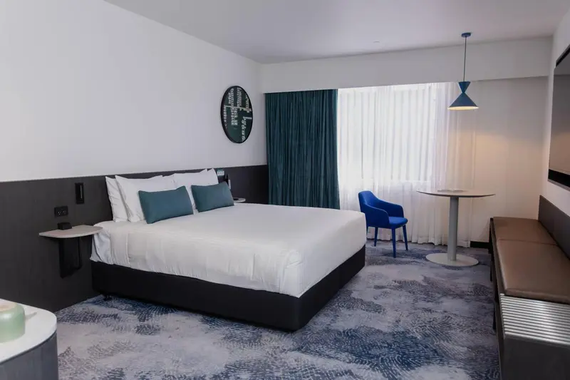 Une chambre lumineuse avec un grand lit et une table ronde.