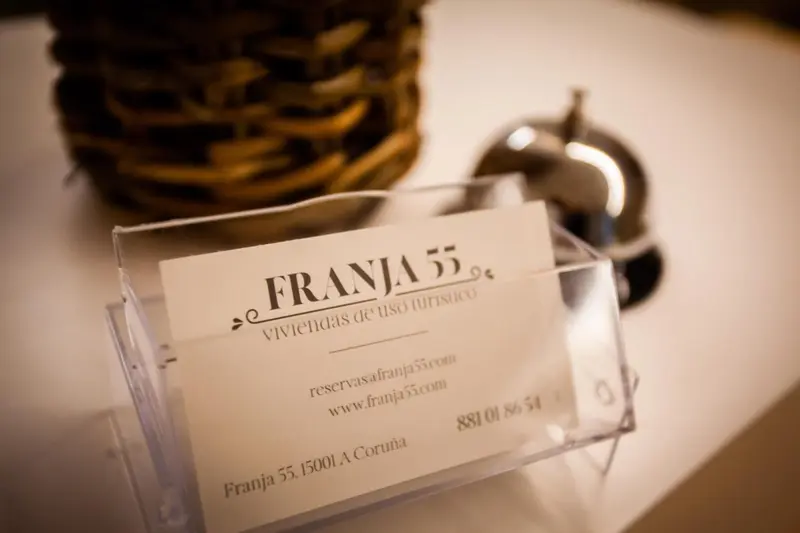 Une carte de visite dans un présentoir transparent sur une surface en bois.