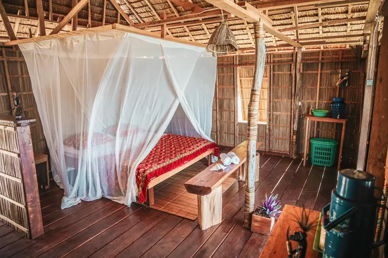 Une chambre rustique avec un lit recouvert d'une moustiquaire.