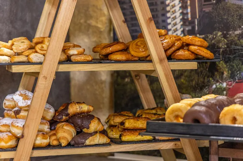 Présentation de viennoiseries sur un étal à plusieurs niveaux.