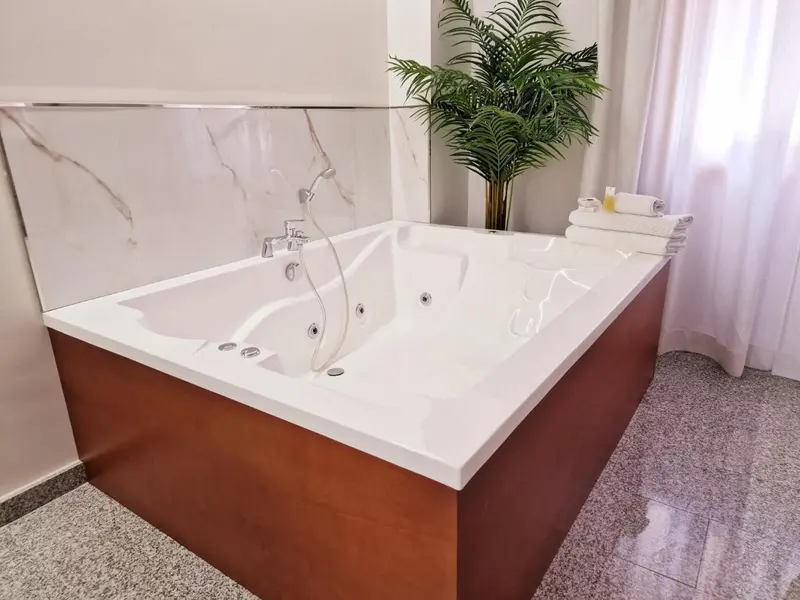 Une baignoire d'angle moderne se trouve dans une salle de bain lumineuse.