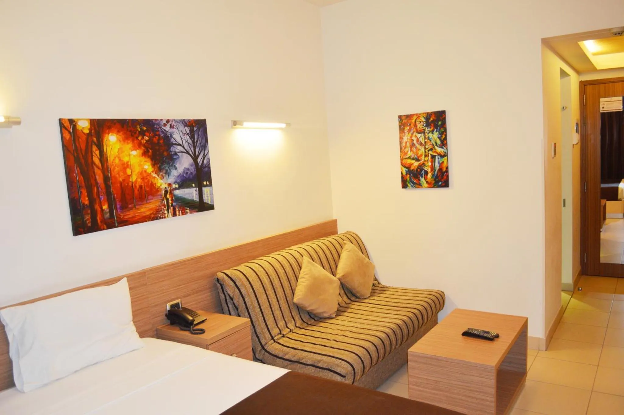 Espace de détente avec canapé et tableaux décoratifs.
