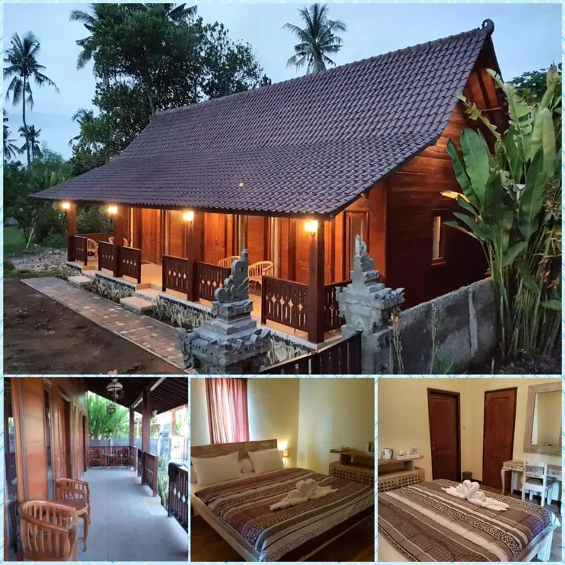 Petite maison en bois sur pilotis avec une terrasse et une végétation tropicale.