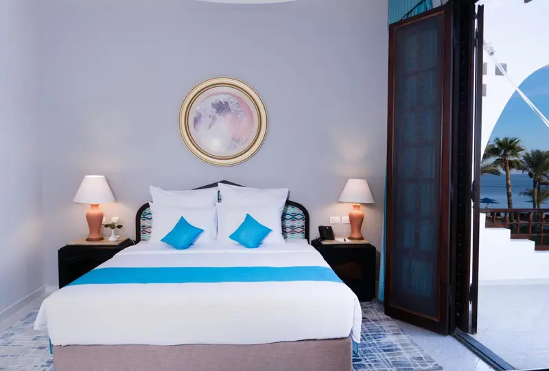 Une chambre lumineuse avec un grand lit et un accès à une terrasse.