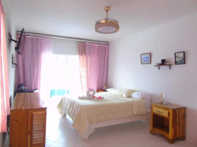 Une chambre lumineuse avec un grand lit et une décoration florale.