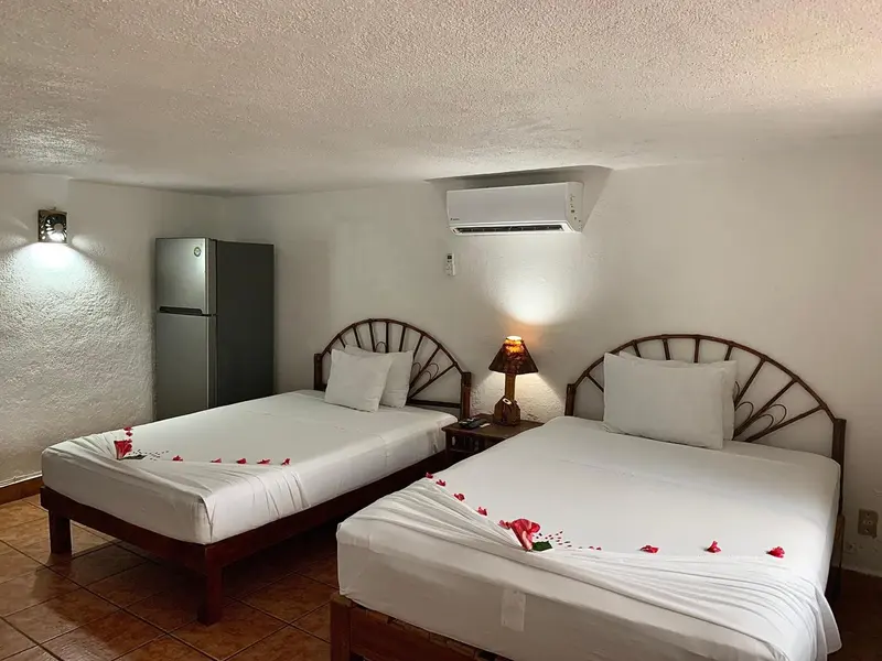 Une chambre avec deux lits simples décorés de pétales de fleurs.