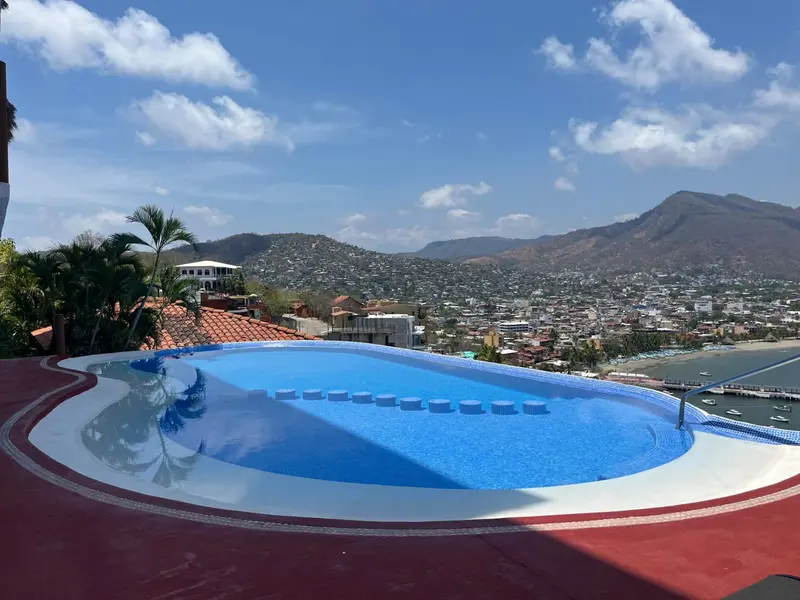 Piscine à débordement avec vue sur la ville et les montagnes.