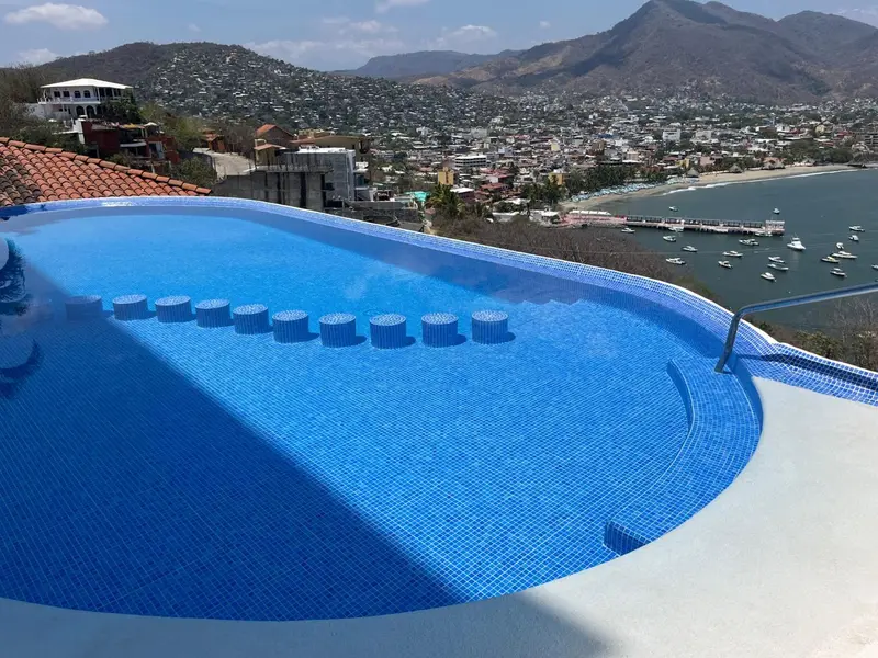 Piscine à débordement avec vue sur la ville et la mer.