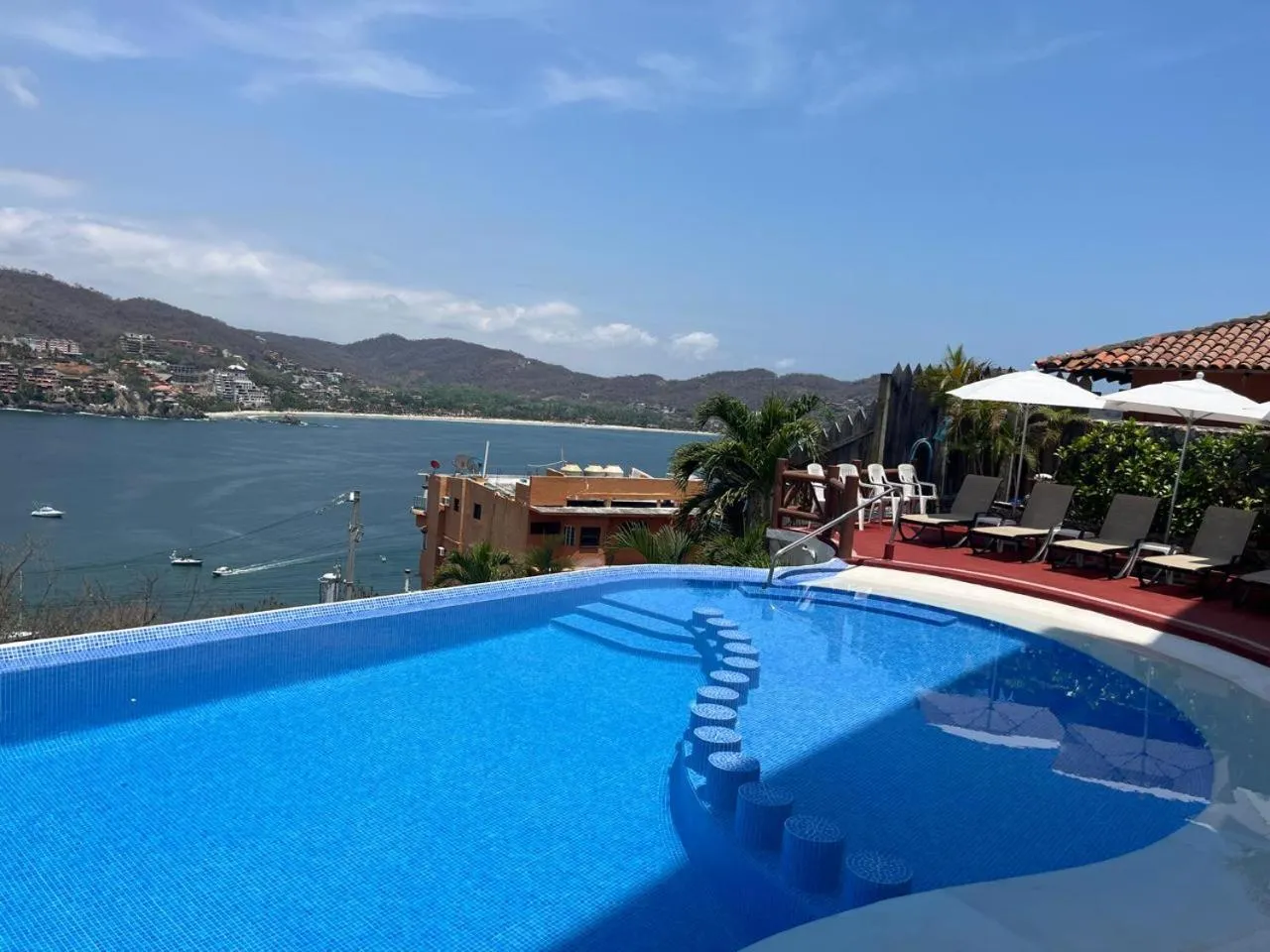 Piscine à débordement avec vue sur la mer et les montagnes.