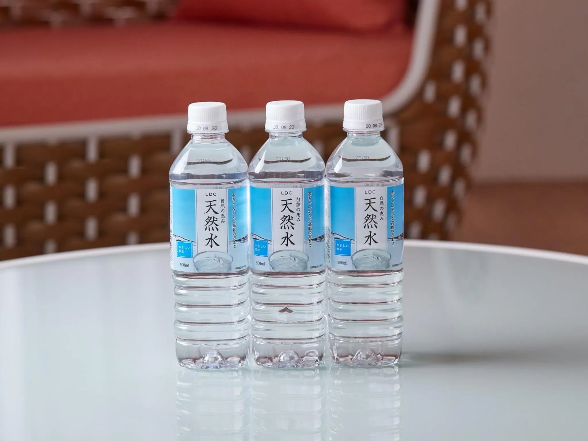 Bouteilles d'eau fraîches alignées sur une table en plastique.