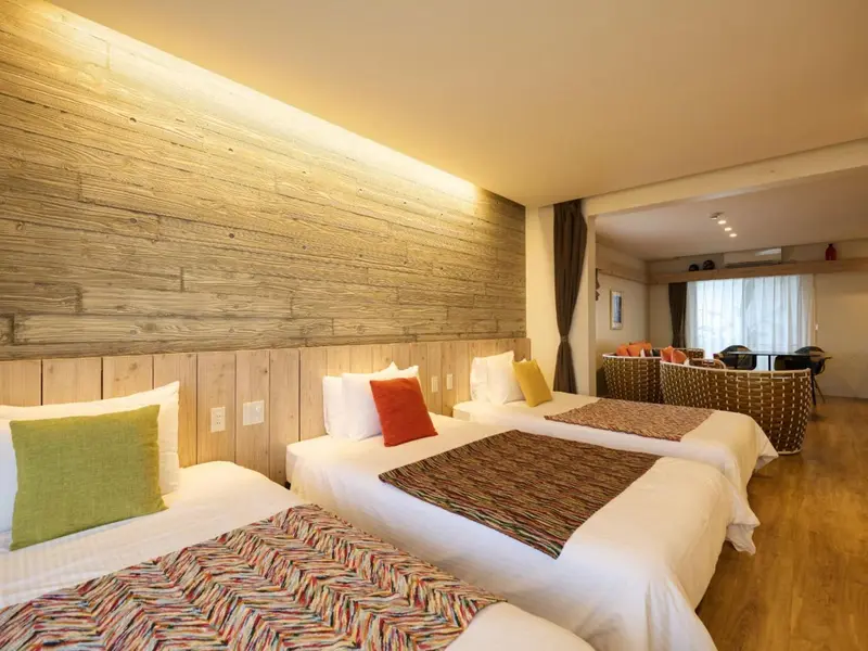 Une chambre avec deux lits simples et une décoration murale en bois.