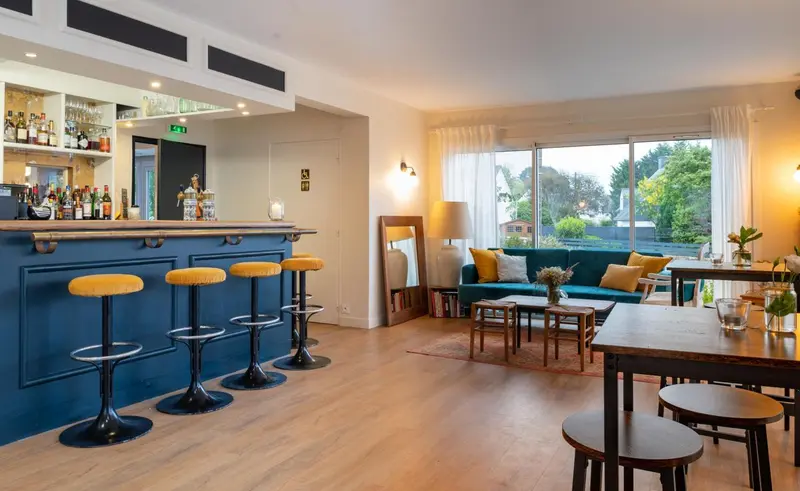 Un espace de détente avec un bar et des canapés près d'une grande fenêtre.