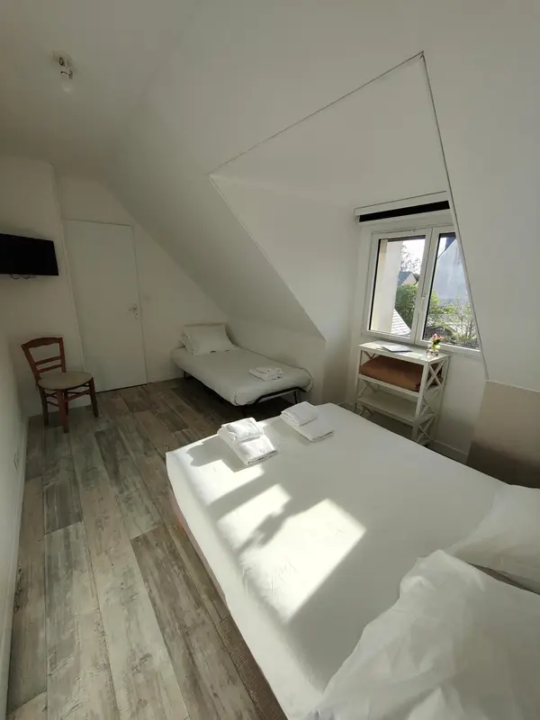 Une chambre lumineuse avec un lit simple et un lit double.