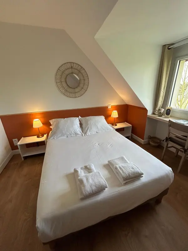 Une chambre lumineuse avec un grand lit et une décoration murale.